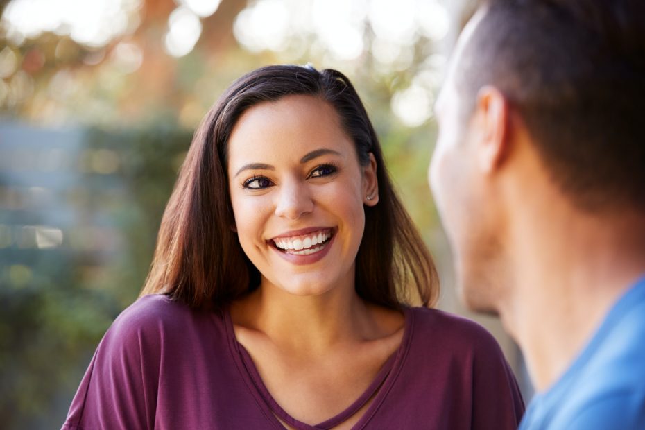 Smiling Hispanic Couple Talking And Laughing In Garden At Home